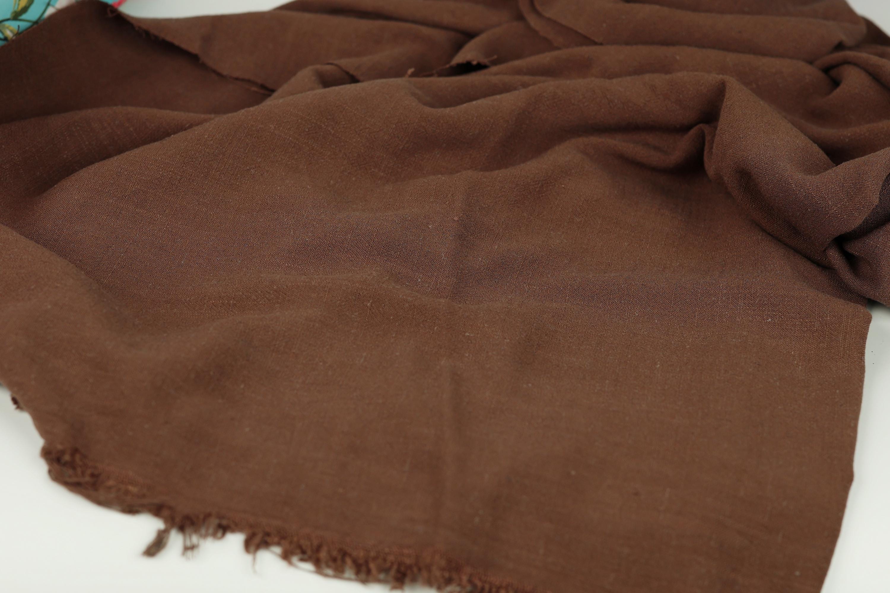 A brown fabric, possibly a scarf or blanket, is spread out on a surface.