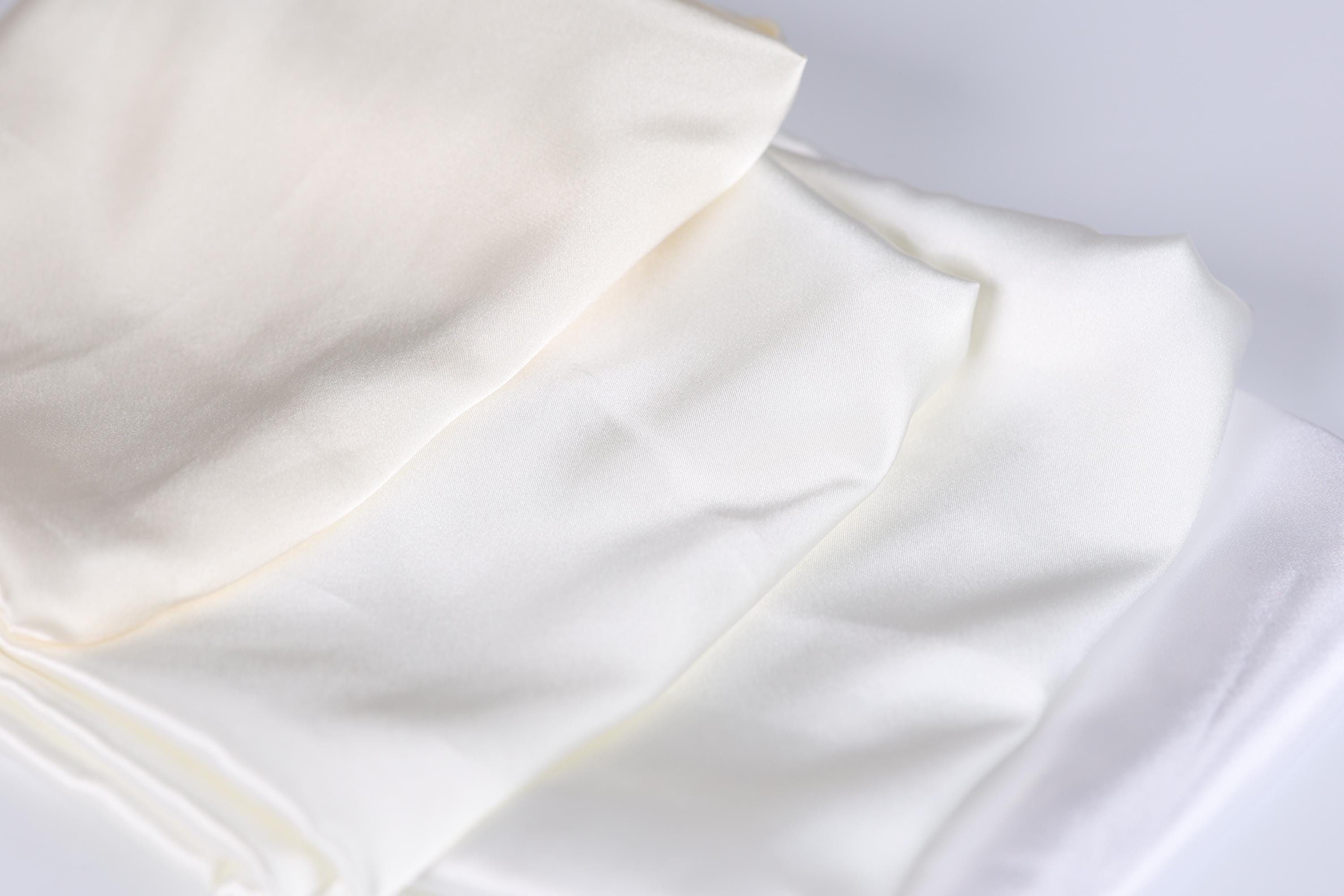 a close-up view of a white fabric, possibly a piece of clothing or a textile, with a slightly crumpled texture.