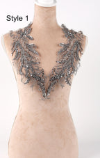 A mannequin wearing a beige dress with a decorative silver and black embellished neckline.