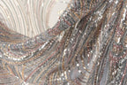 a close-up view of a fabric with a shimmering, sequined texture in shades of silver, gold, and pink. The fabric appears to be made of a sheer material, giving it a delicate and elegant appearance.
