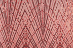 a close-up view of a fabric with a repeating pattern of red and black sequin designs. The pattern consists of diagonal lines and shapes, creating a visually striking and intricate design.