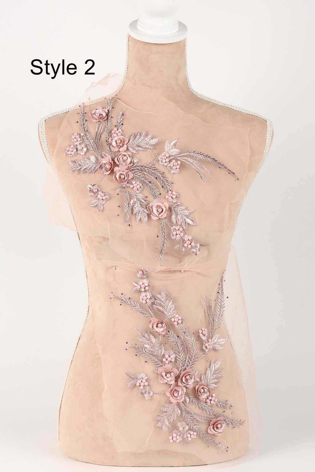 A mannequin with a beige body and a floral design on its torso, featuring pink flowers and leaves.
