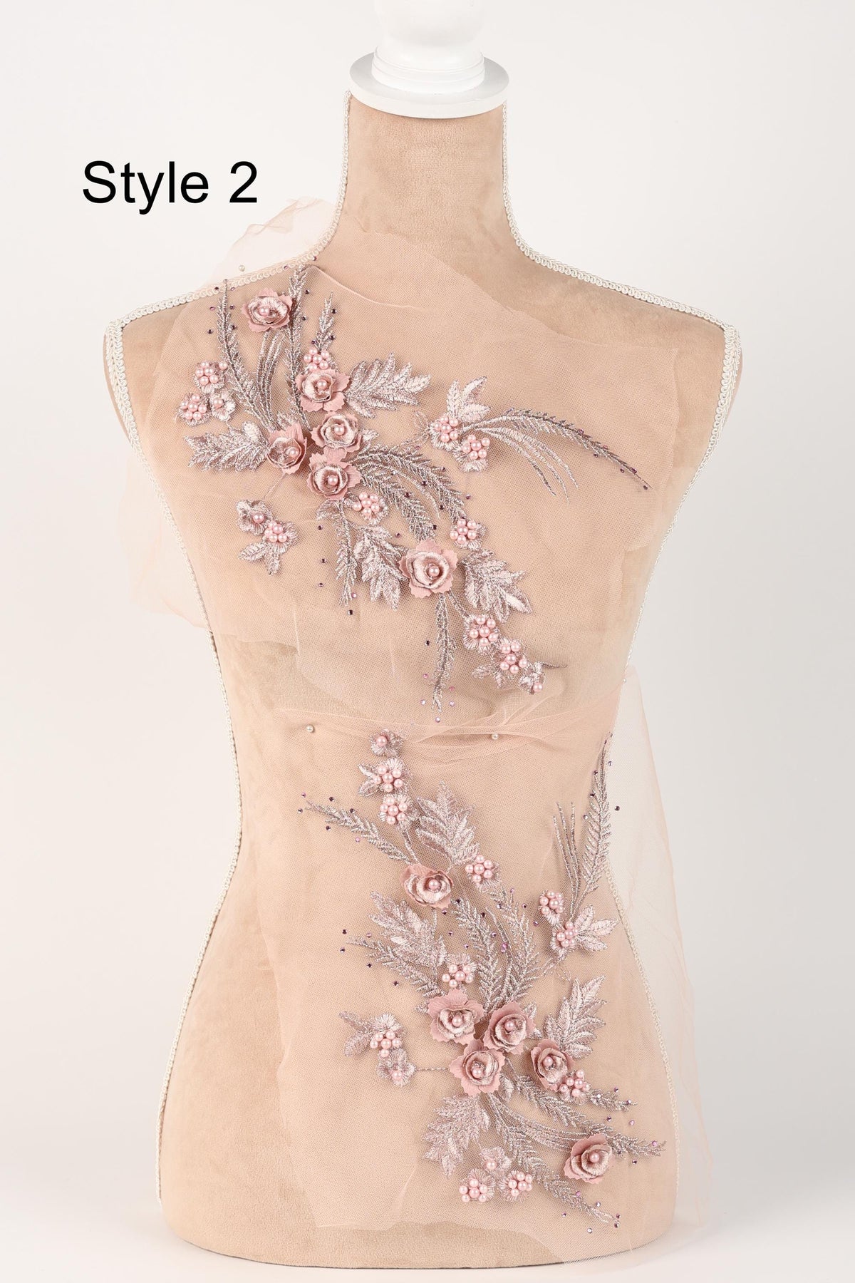 A mannequin with a beige body and a floral design on its torso, featuring pink flowers and leaves.