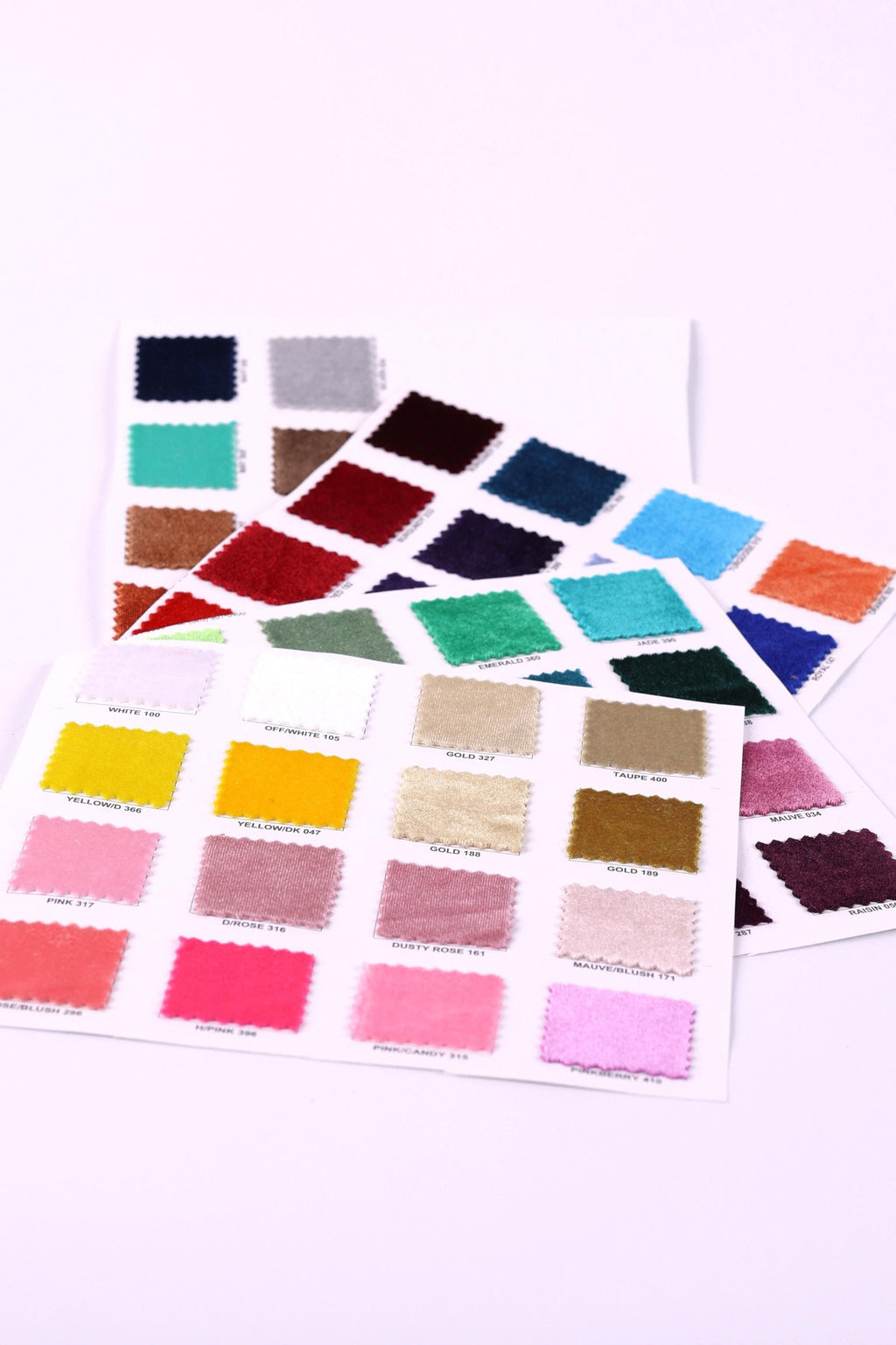 a collection of fabric swatches in various colors, including pink, blue, green, and yellow, arranged on a white background.