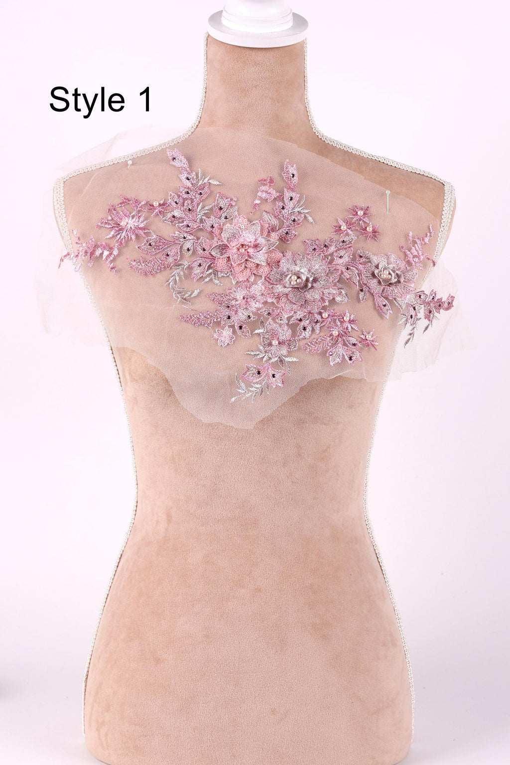 A mannequin with a pink floral embroidered patch on its shoulder.