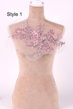 A mannequin with a pink floral embroidered patch on its shoulder.