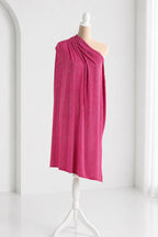 A mannequin wearing a vibrant pink one-shoulder dress stands on a white stand against a white background.