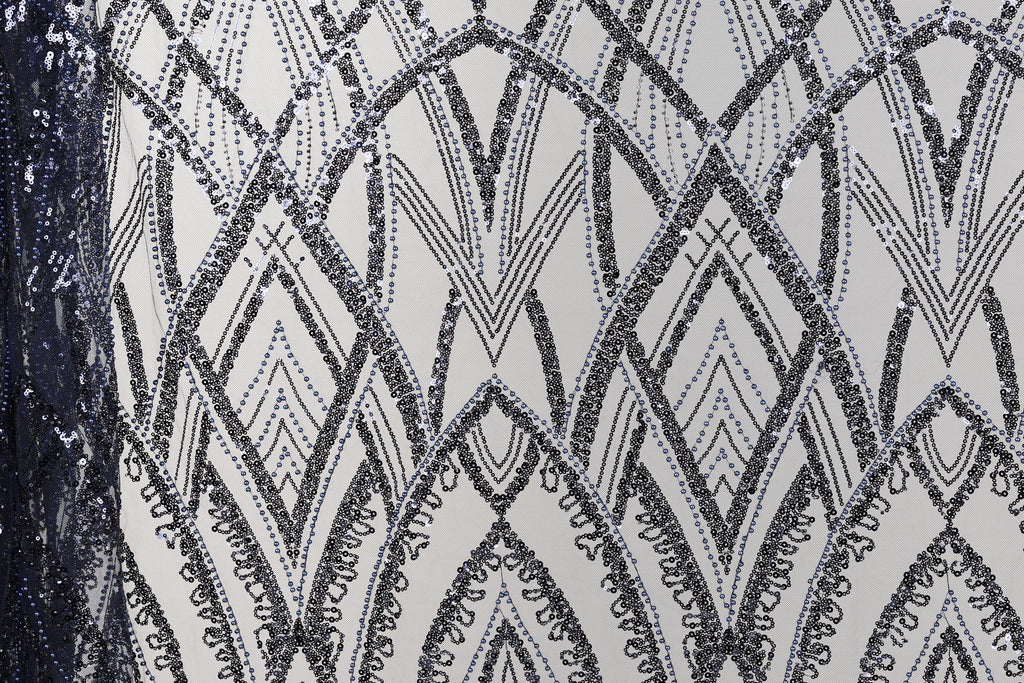 a close-up view of a fabric with a repeating pattern of black and white diamond shapes, creating an intricate and visually striking design.