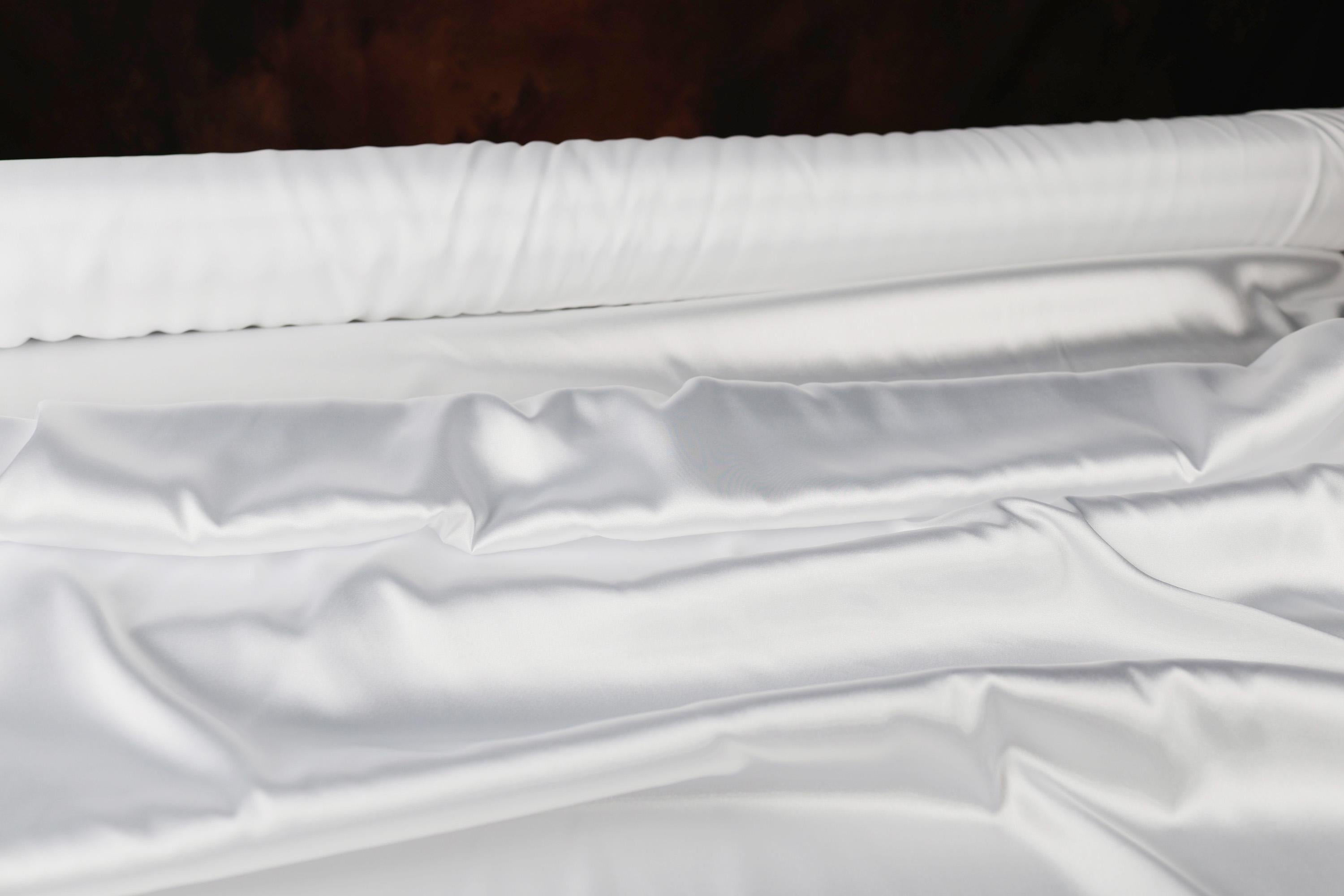 a close up of a bed with white sheets