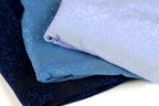 three fabric pieces with a glittery texture, stacked on top of each other.