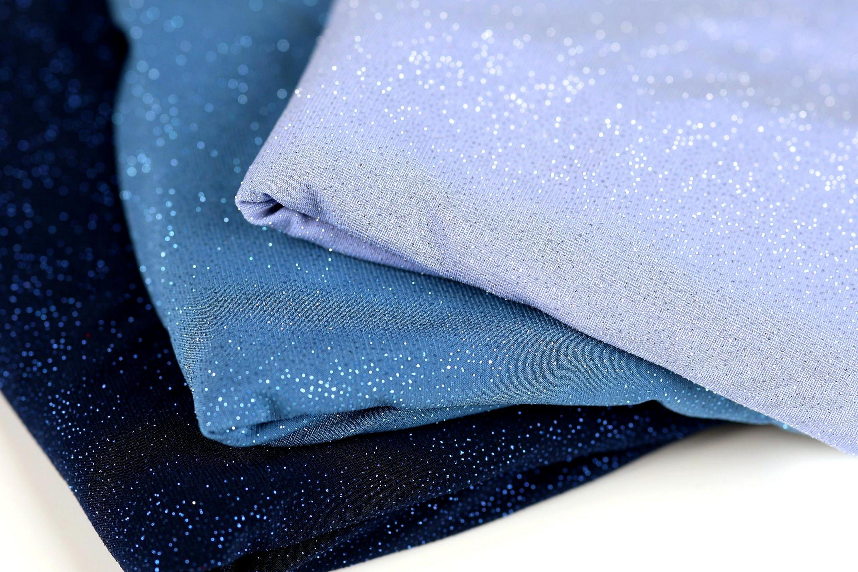 three fabric pieces with a glittery texture, stacked on top of each other.