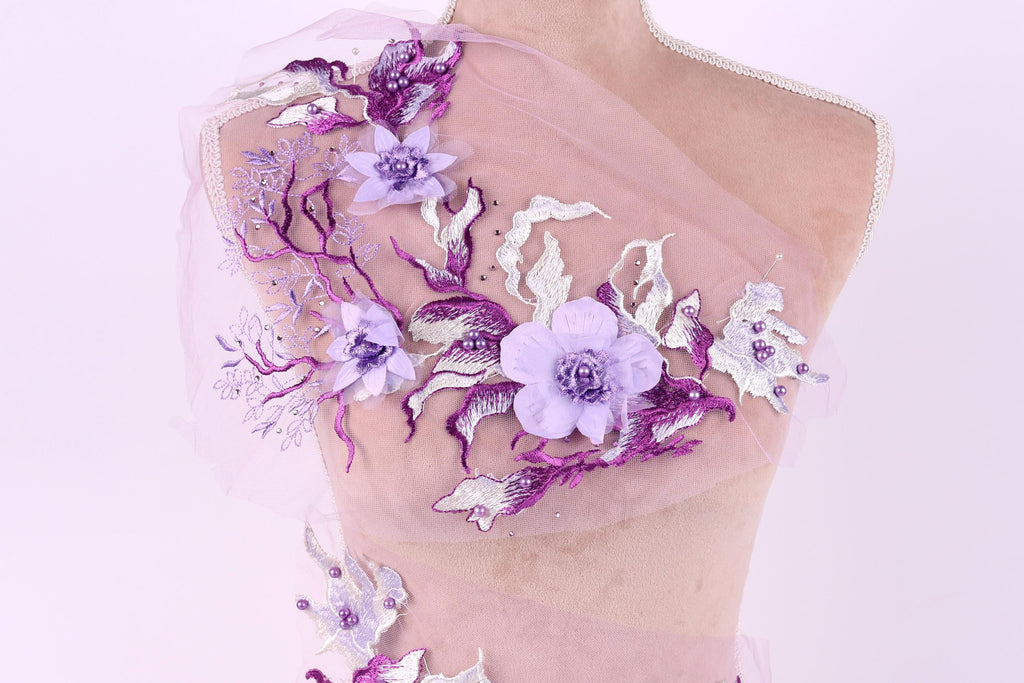 A mannequin wearing a dress with a delicate floral pattern in shades of purple and white.