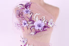 A mannequin wearing a dress with a delicate floral pattern in shades of purple and white.