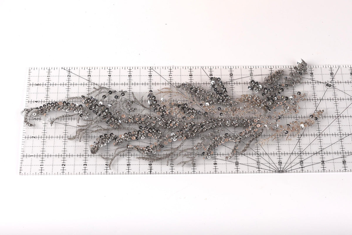 a collection of sequin pieces and a ruler on a white background.