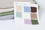 a collection of fabric swatches, each with a different color and pattern, arranged on a white surface.
