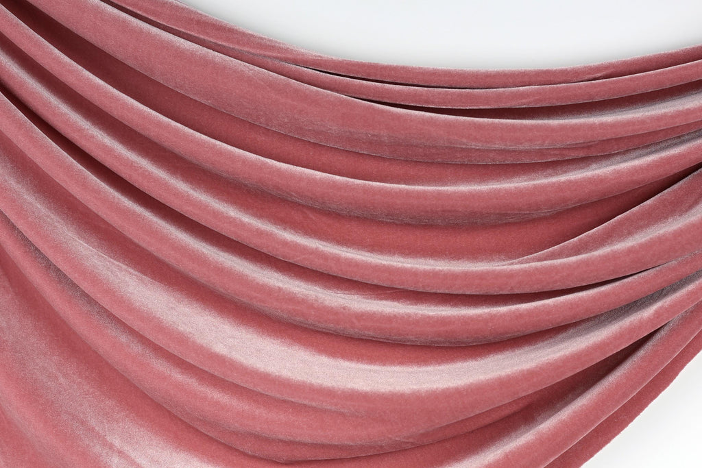 a close-up view of a red velvet fabric, with its folds and creases creating a textured and flowing appearance.