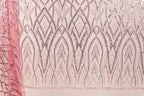 a close-up view of a fabric with a repeating pattern of pink and black lines and shapes, creating a visually striking and intricate design.