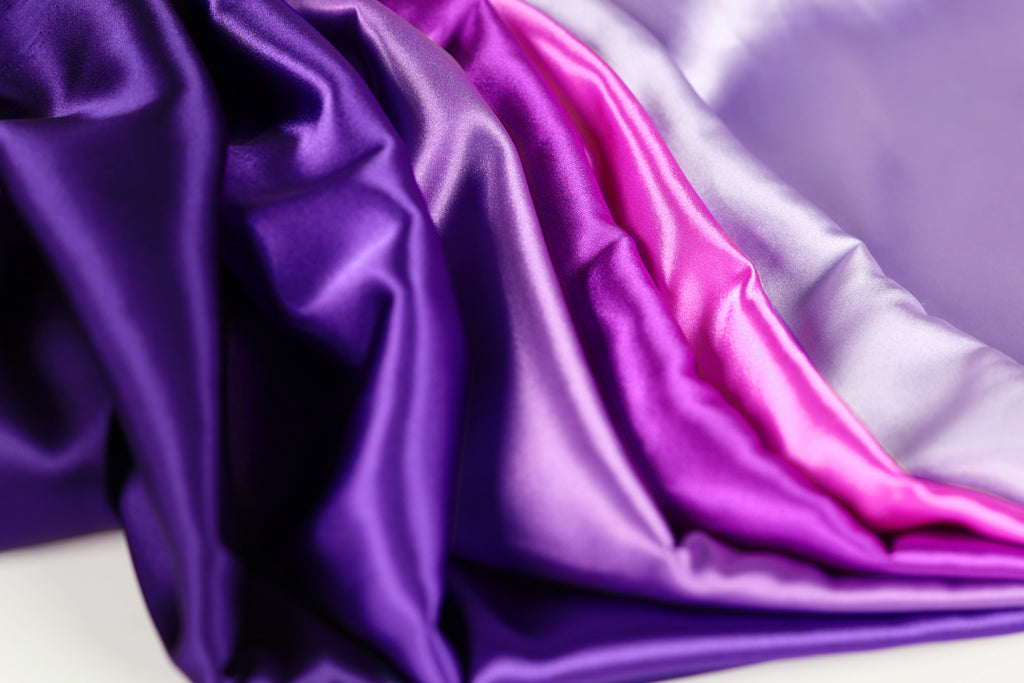 a close-up view of a fabric with a purple and pink color gradient, creating a visually appealing and vibrant pattern.