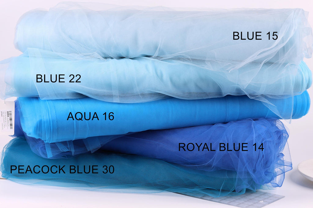 A stack of various blue fabric swatches, each labeled with a different color and type of fabric.