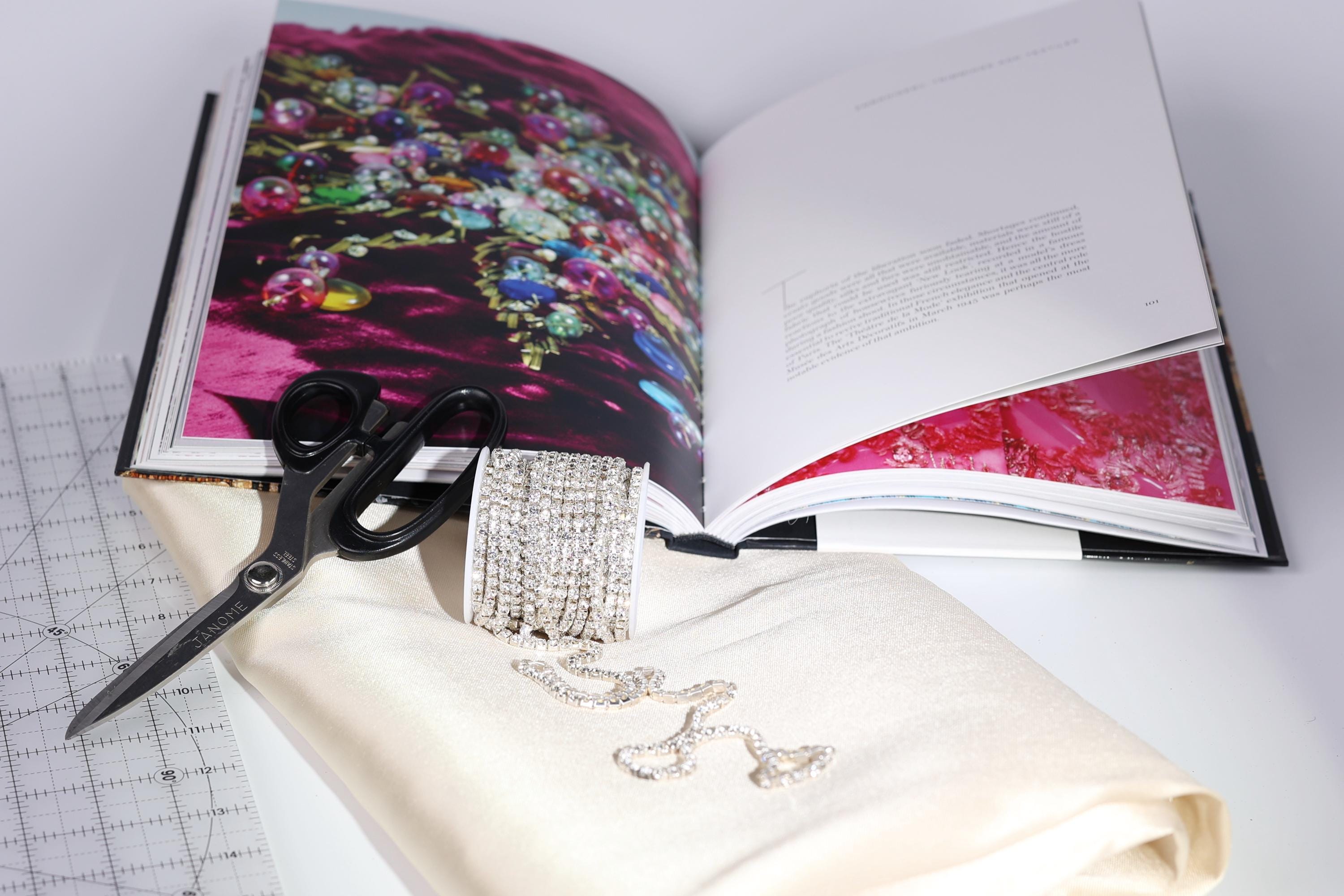 a collection of jewelry and a book, with the jewelry items including a bracelet, a ring, and a necklace, and the book displaying a colorful photograph.