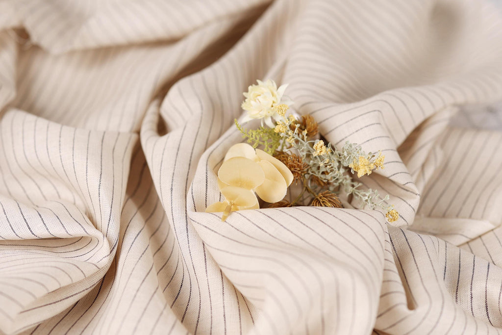 A close-up view of a fabric with a floral arrangement of yellow and white flowers resting on it.