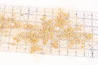 a close-up view of a transparent ruler with gold-colored floral designs on it.