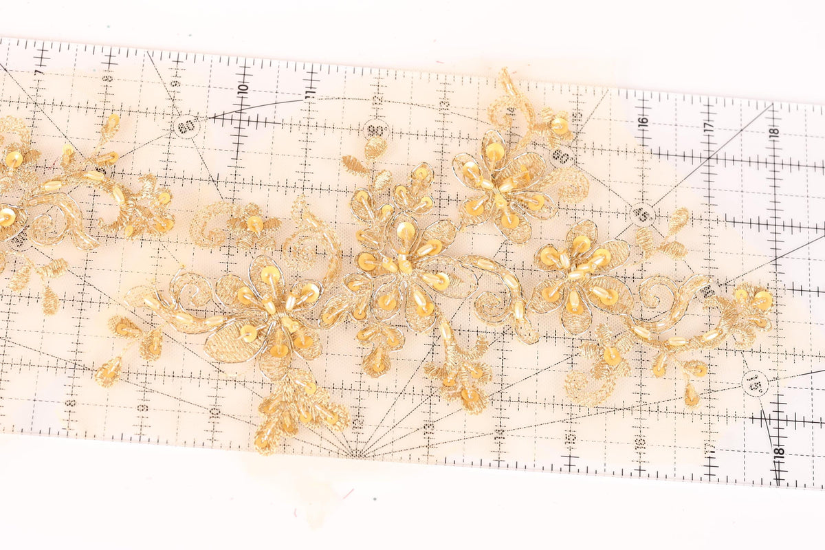 a close-up view of a transparent ruler with gold-colored floral designs on it.