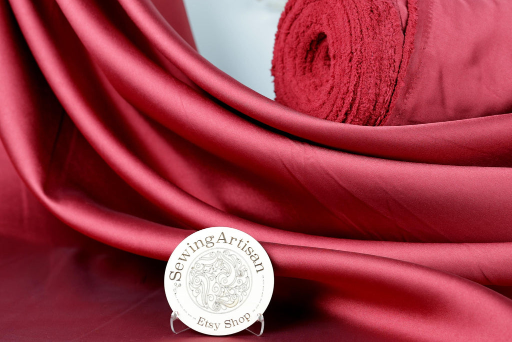 a red fabric with a round sign in the foreground that reads "Sewing artisan Esy shop".