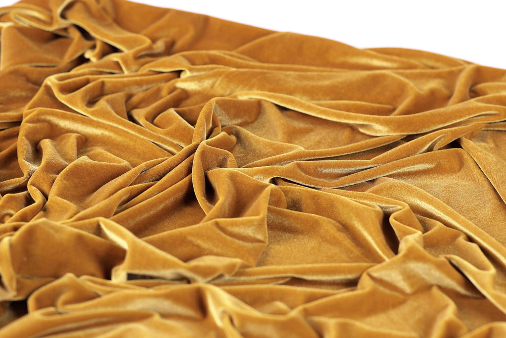a close-up view of a crumpled, golden-colored fabric, possibly velvet, with a textured and wrinkled appearance.