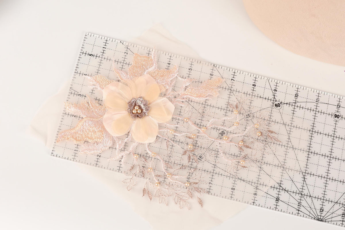 a clear ruler with a delicate flower design on it, placed on a white surface.