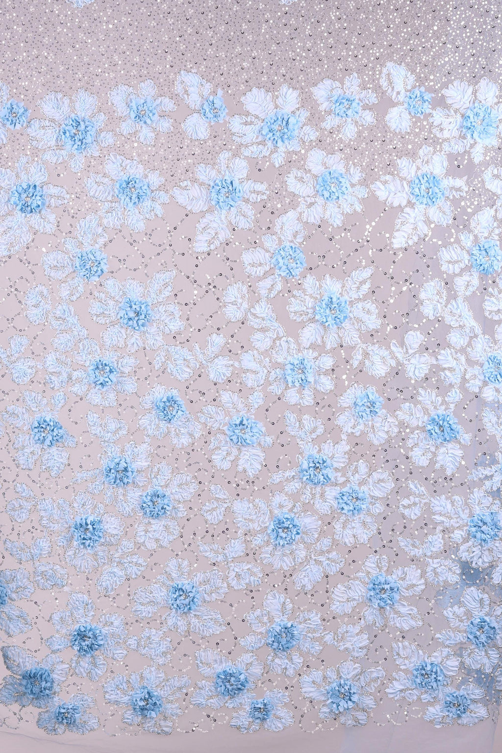 a close-up view of a fabric with a floral pattern. The fabric is adorned with numerous small blue flowers, each with delicate petals, creating a visually appealing and intricate design. The flowers are scattered across the fabric in a random yet harmonious arrangement, adding a sense of depth and texture to the overall composition.