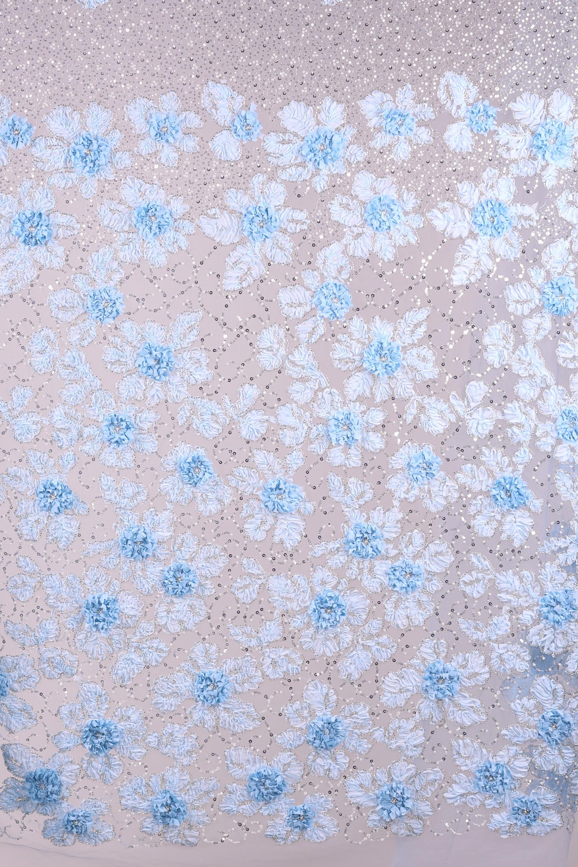 a close-up view of a fabric with a floral pattern. The fabric is adorned with numerous small blue flowers, each with delicate petals, creating a visually appealing and intricate design. The flowers are scattered across the fabric in a random yet harmonious arrangement, adding a sense of depth and texture to the overall composition.