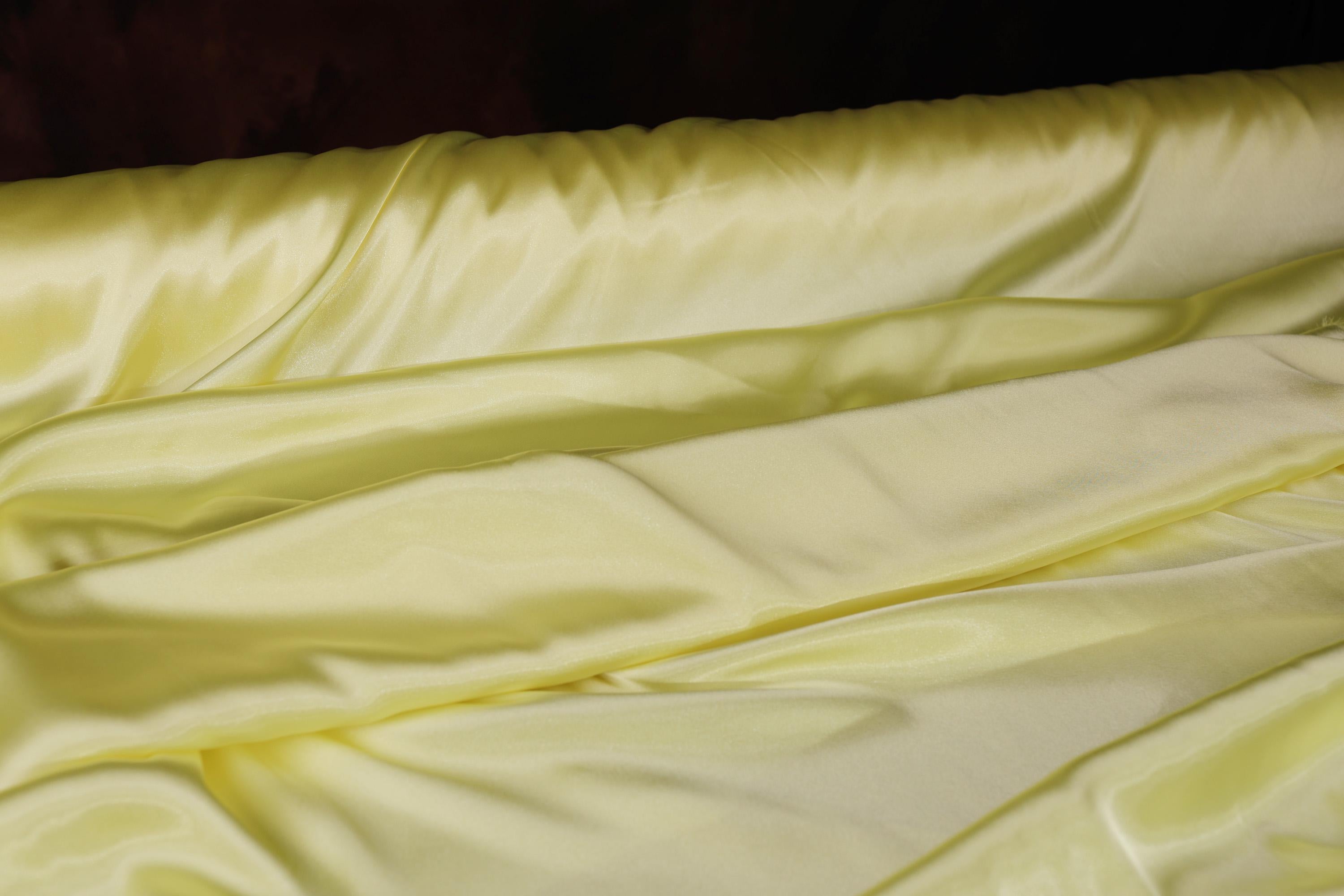a close up of a bed with a yellow comforter