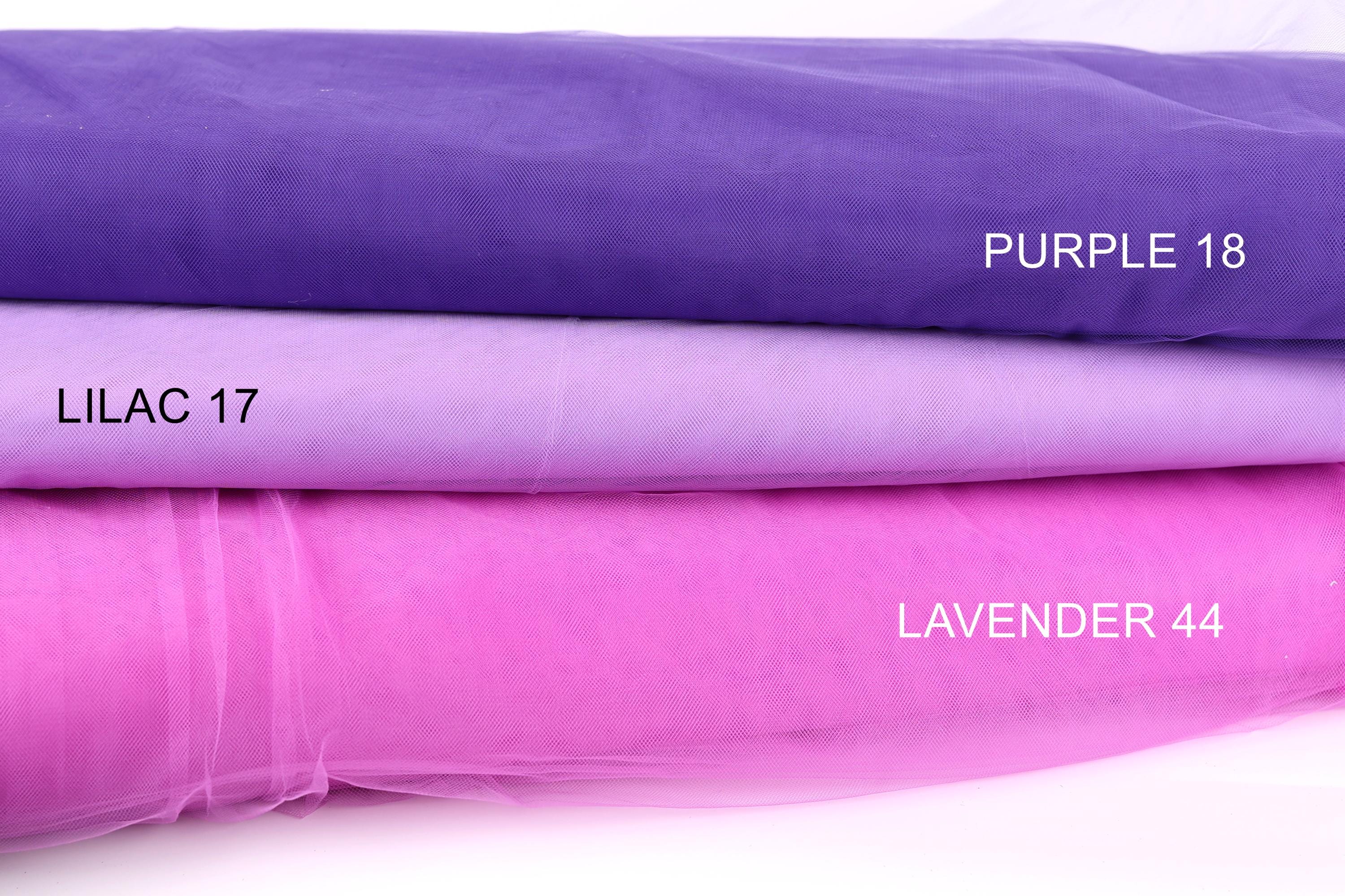 three fabric swatches, each with a different color: purple, lavender, and a shade of purple called lilac. The swatches are arranged in a stack, with the purple fabric on top and the lavender fabric below.