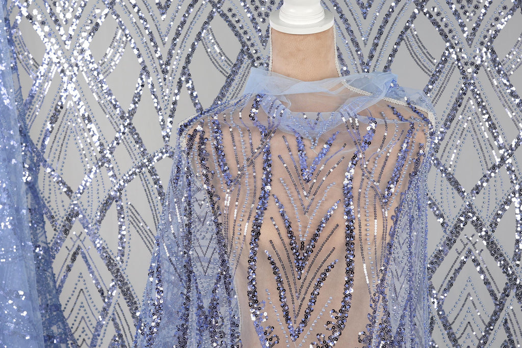 a mannequin wearing a sequin cape with a blue and silver pattern.