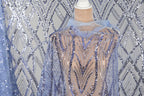 a mannequin wearing a sequin cape with a blue and silver pattern.