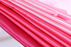 A close-up view of a fabric with a gradient of pink and red colors, creating a visually striking and vibrant appearance.