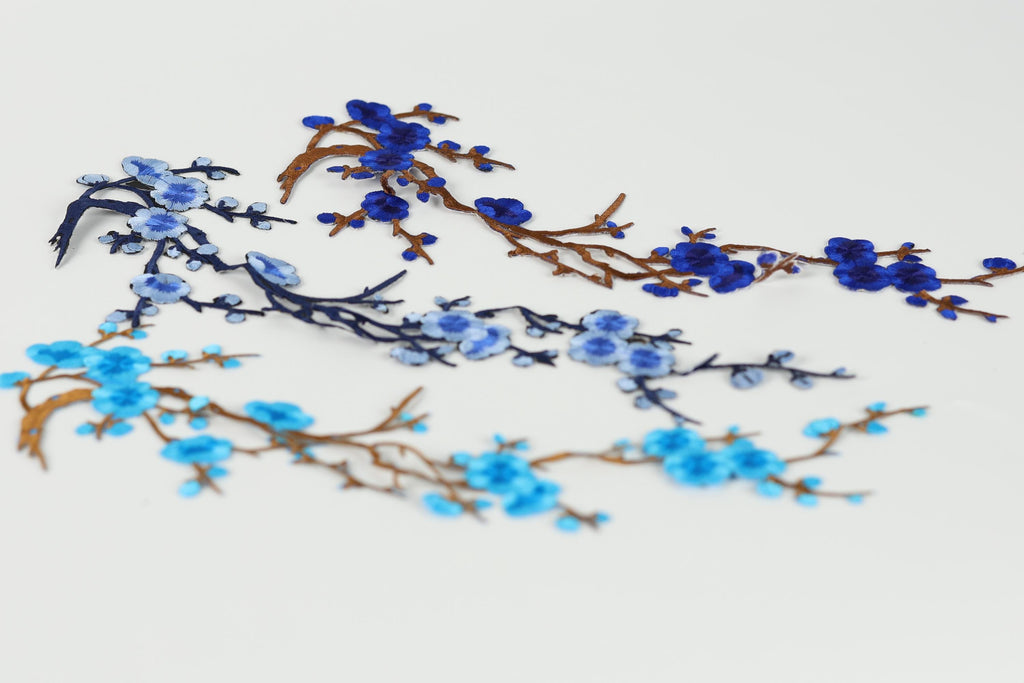 a close-up view of blue and brown branches with blue flowers, creating a visually appealing and intricate design.