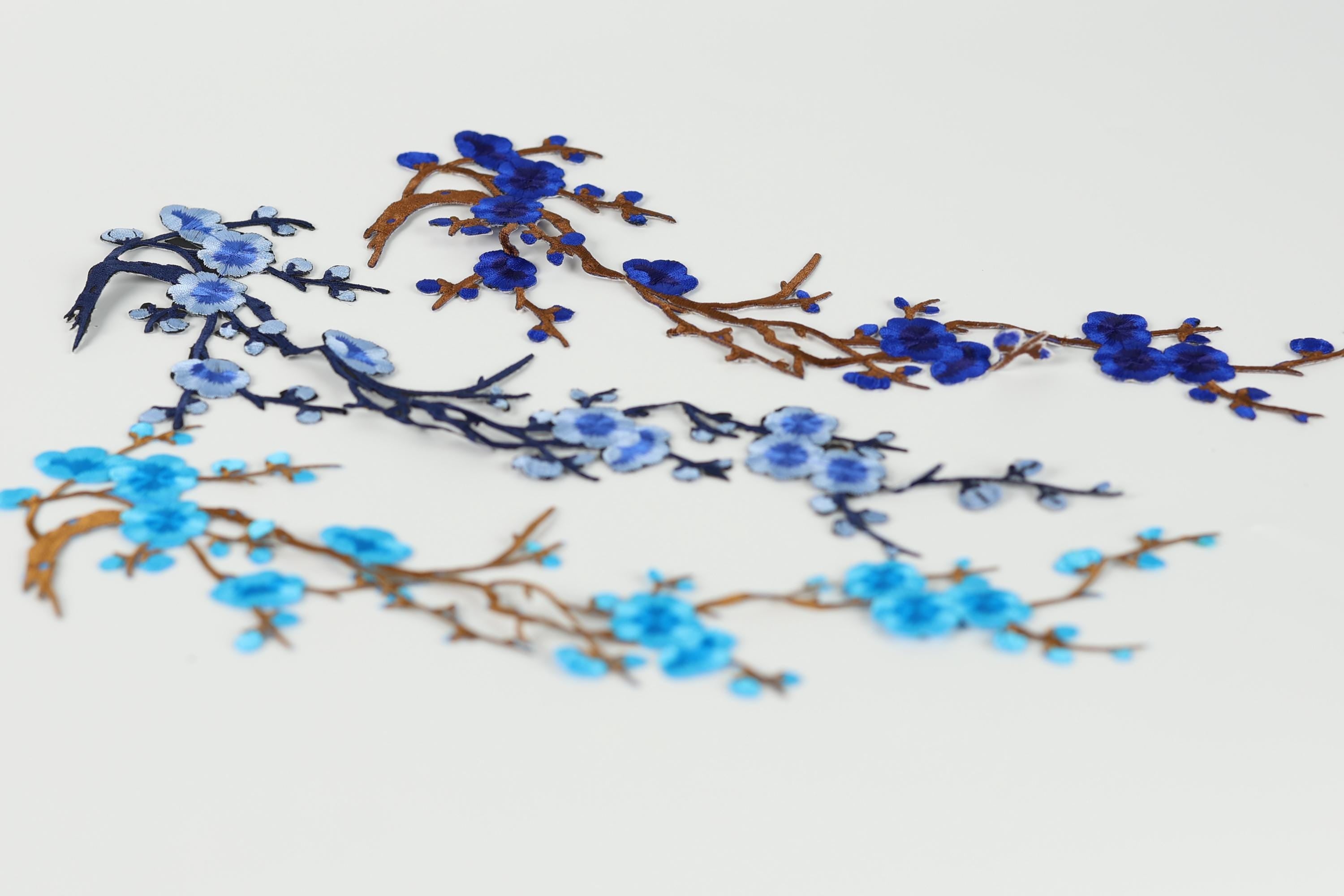 a close-up view of blue and brown branches with blue flowers, creating a visually appealing and intricate design.