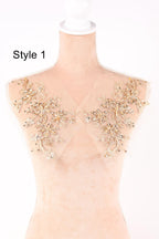 A mannequin with a beige fabric shoulder and gold floral embellishments on the shoulders.