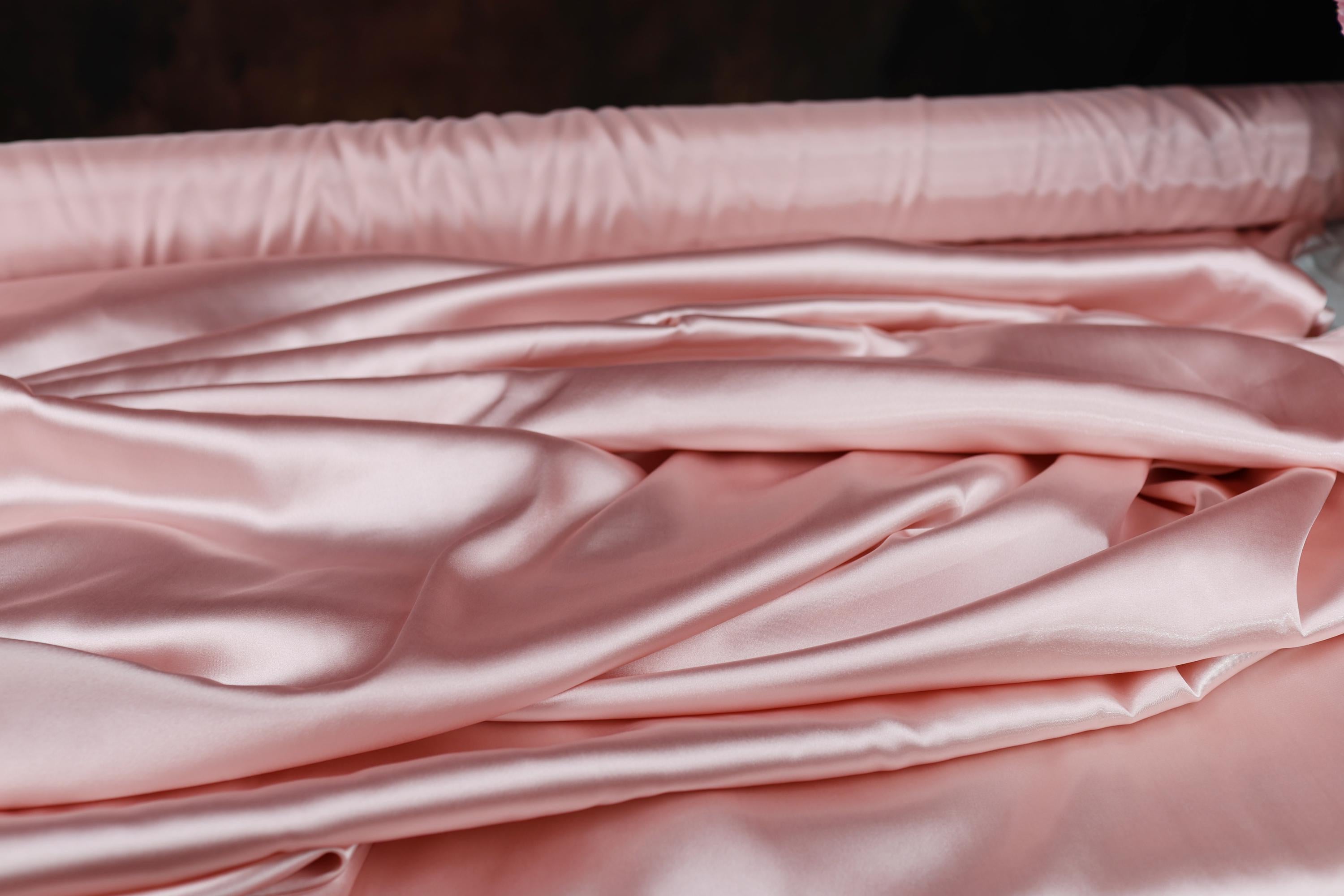 a close up of a bed with pink sheets