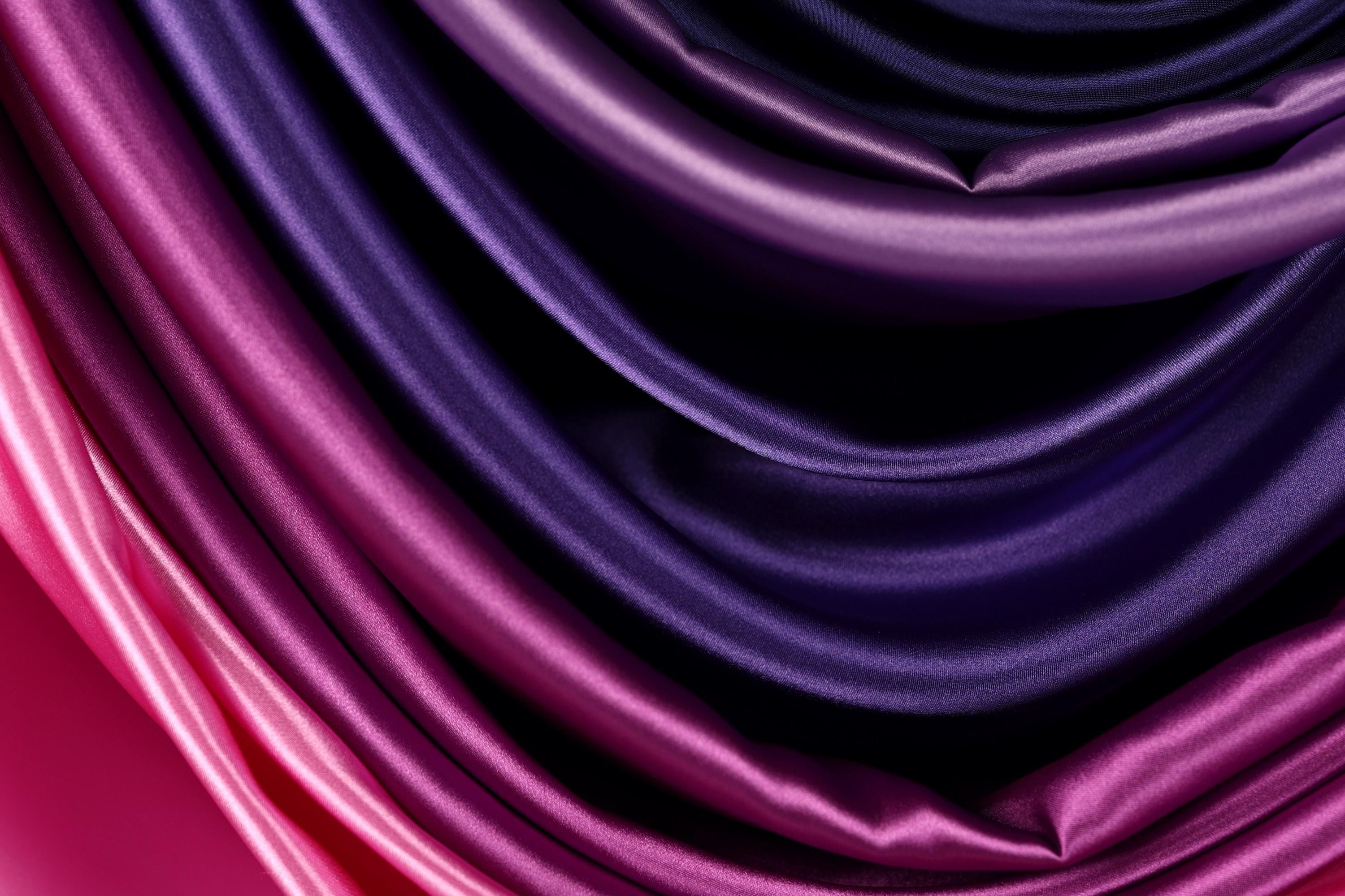a close-up view of a fabric with a gradient of purple and pink colors, creating a visually striking and vibrant pattern.