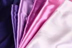 A close-up image of a fabric with a variety of colors, including shades of purple, pink, and white.