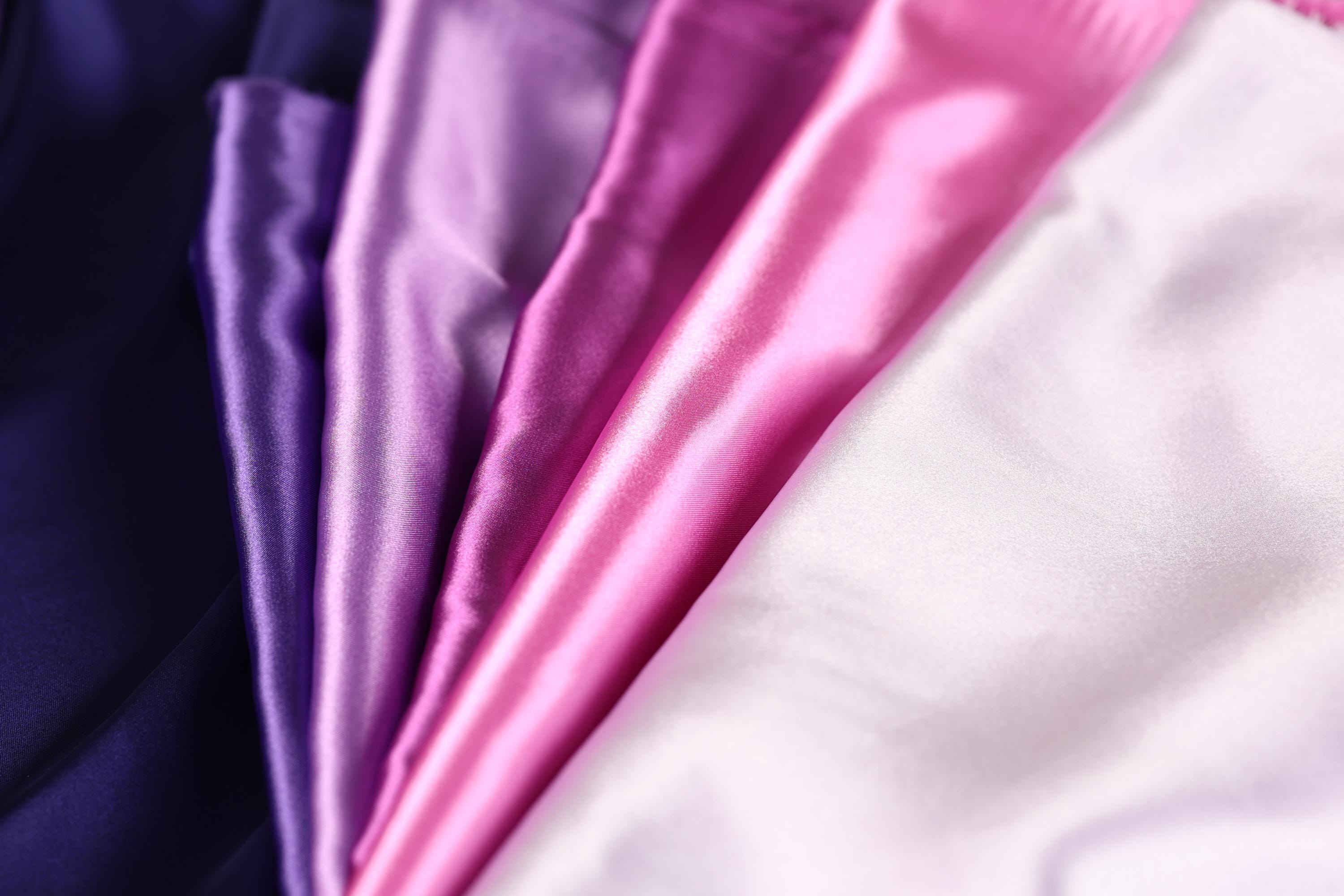 A close-up image of a fabric with a variety of colors, including shades of purple, pink, and white.