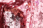 A close-up view of a hand holding a piece of red sequin fabric, with the fabric's intricate patterns and textures visible.