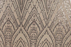 a close-up view of a patterned fabric with a repeating geometric design. The design consists of a series of arched shapes and lines, interspersed with small circular dots. The overall color scheme of the pattern is a mix of brown and beige, with some areas of black and white. The pattern appears to be a decorative textile or fabric, possibly used for clothing or home decor.