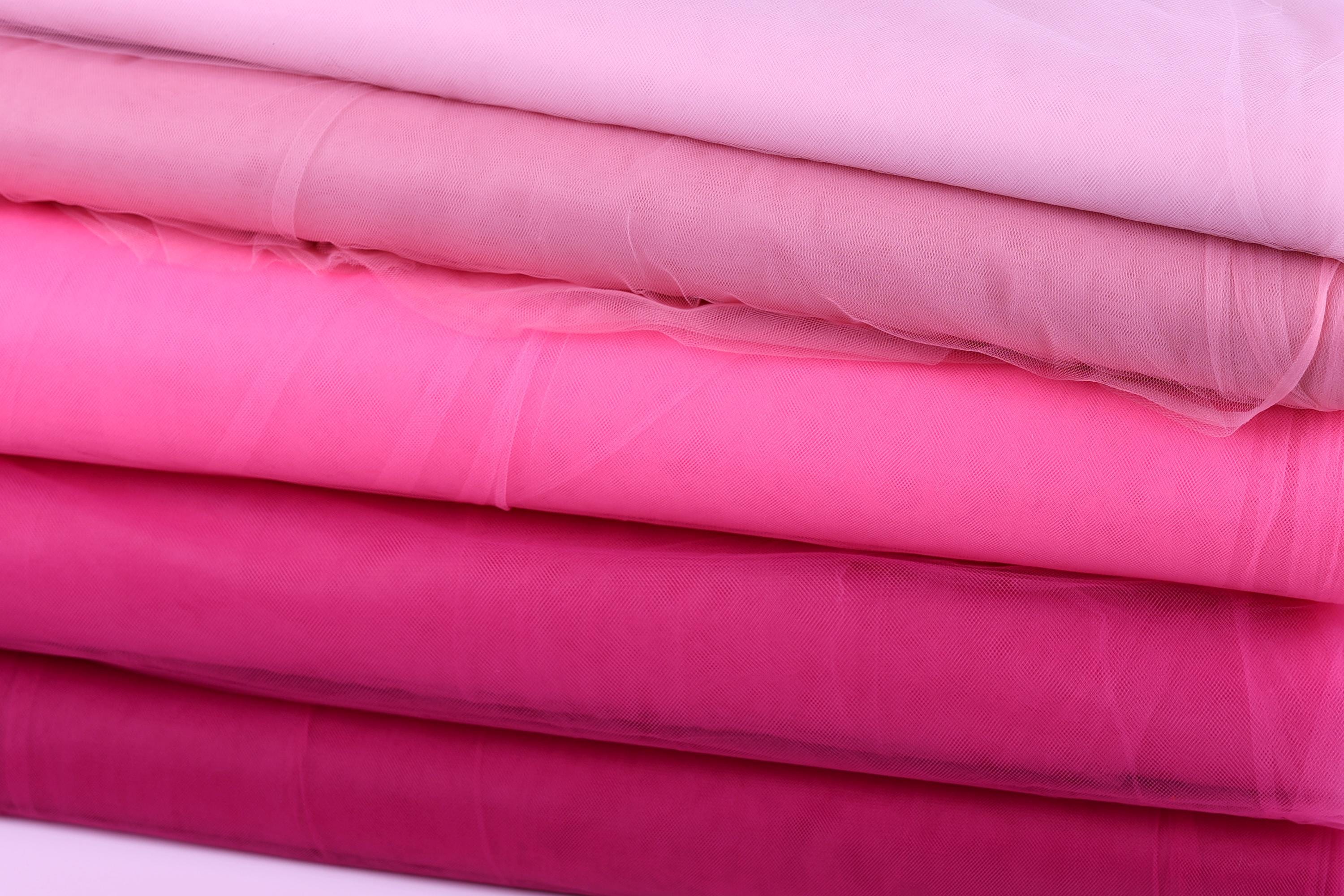 A stack of pink fabric swatches, with each swatch appearing to be a different shade of pink.