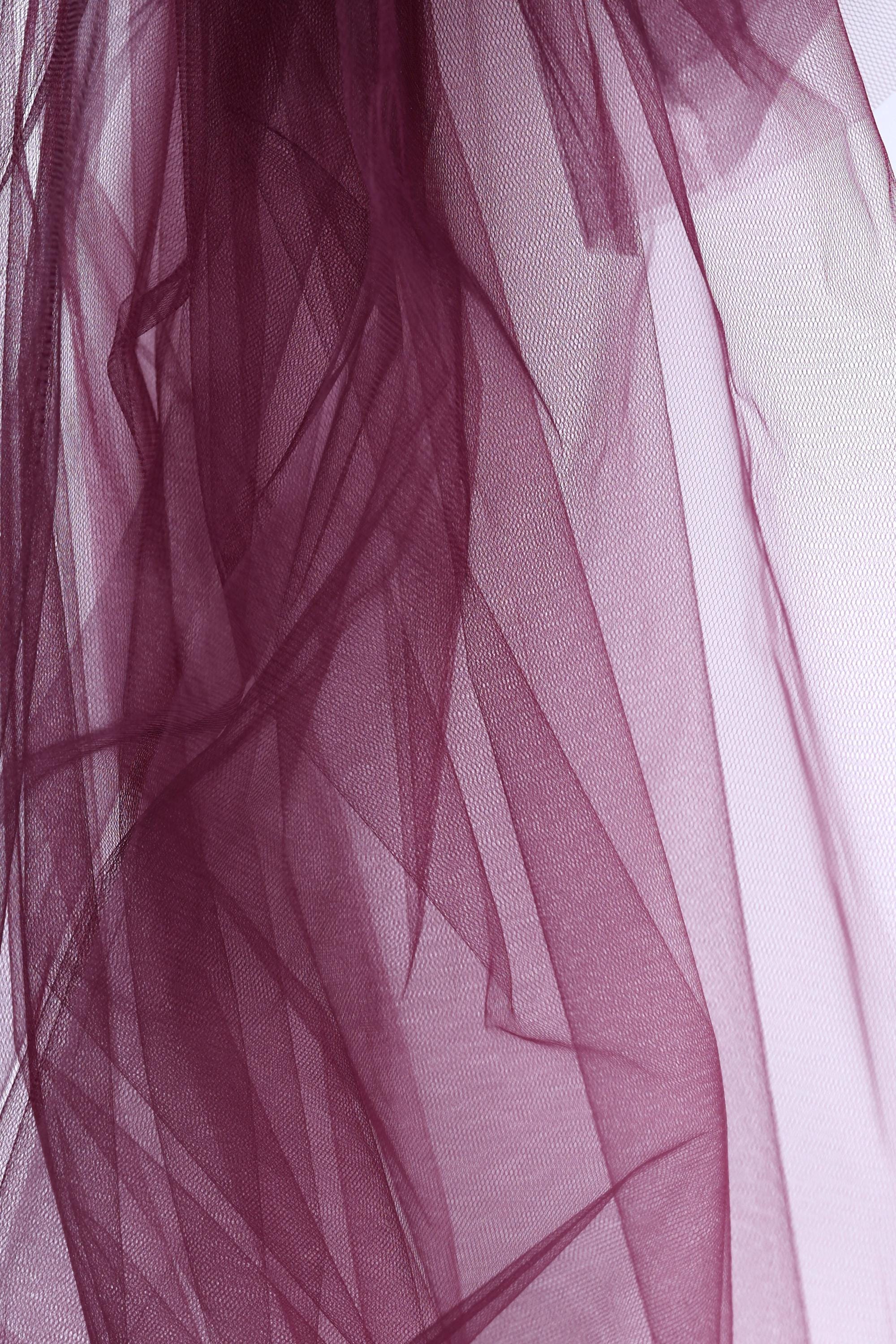 a close-up view of a dark purple tulle fabric, with its intricate and flowing texture visible.