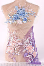 a mannequin with a dress adorned with intricate floral embroidery in shades of blue, pink, and purple.