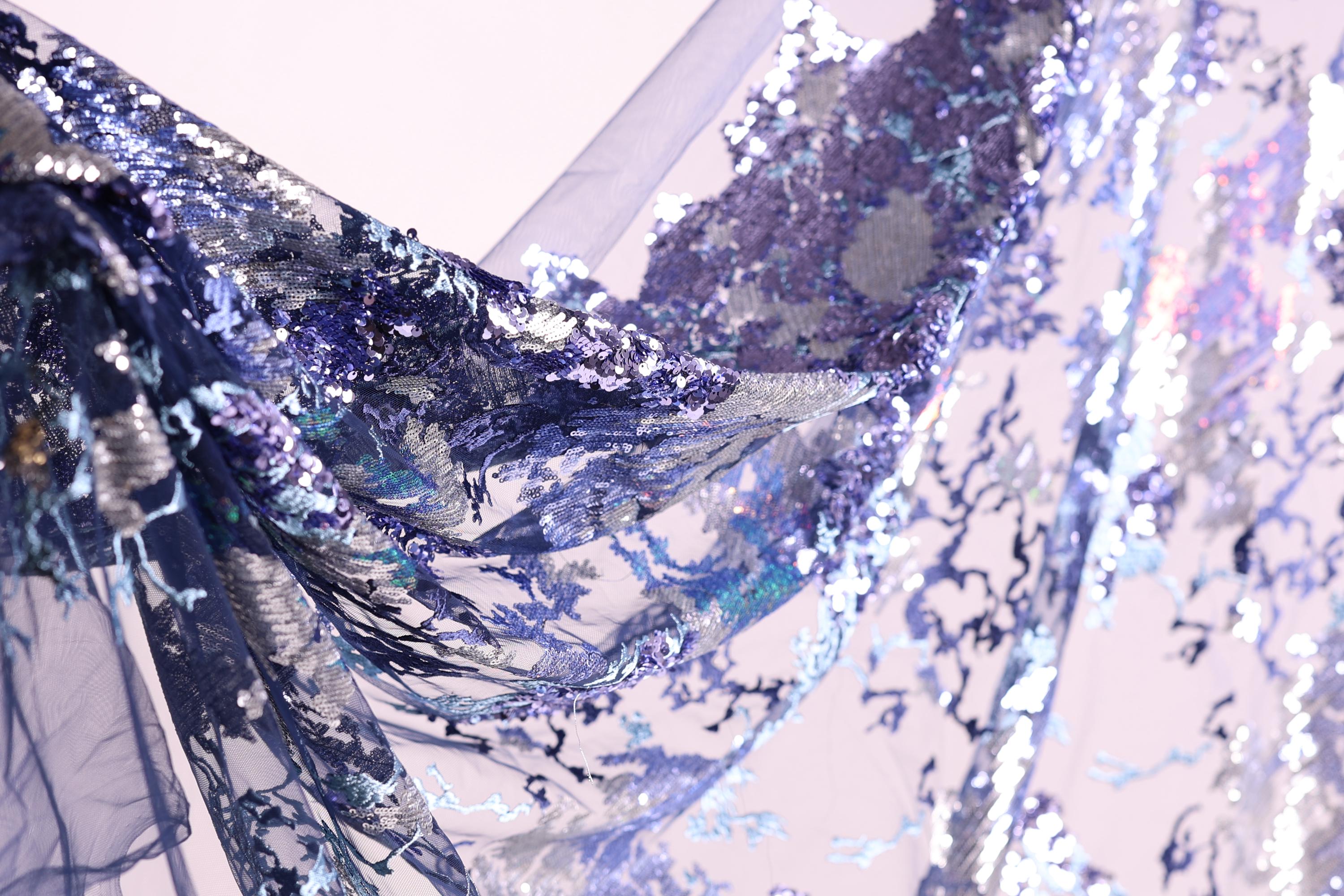 a close-up view of a fabric with a vibrant, multicolored pattern of sequins and threads, creating a visually striking and intricate design.